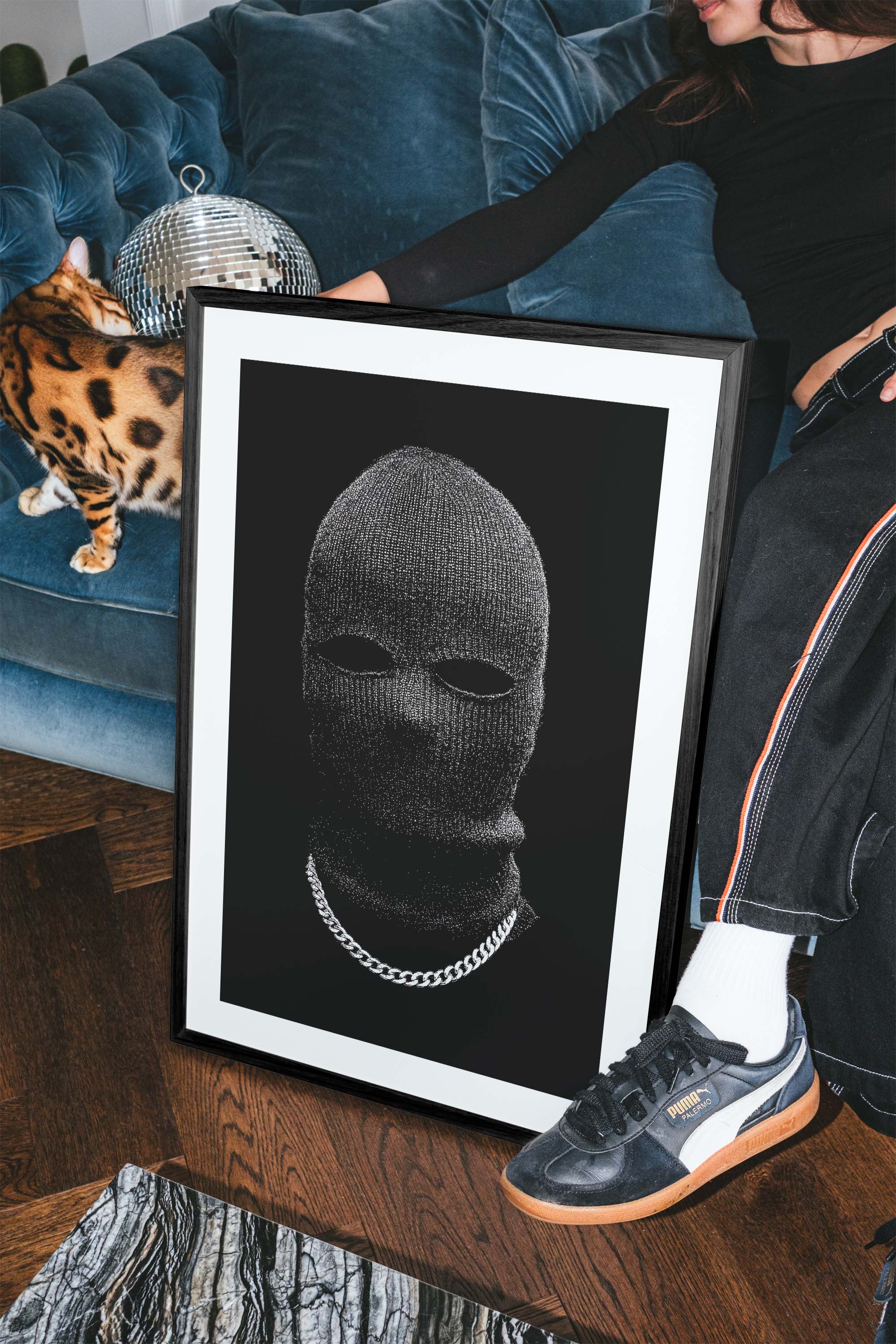 Black-and-white portrait of a person in a knit balaclava with eye cutouts and a silver chain on a solid black background, minimalist fine art print.