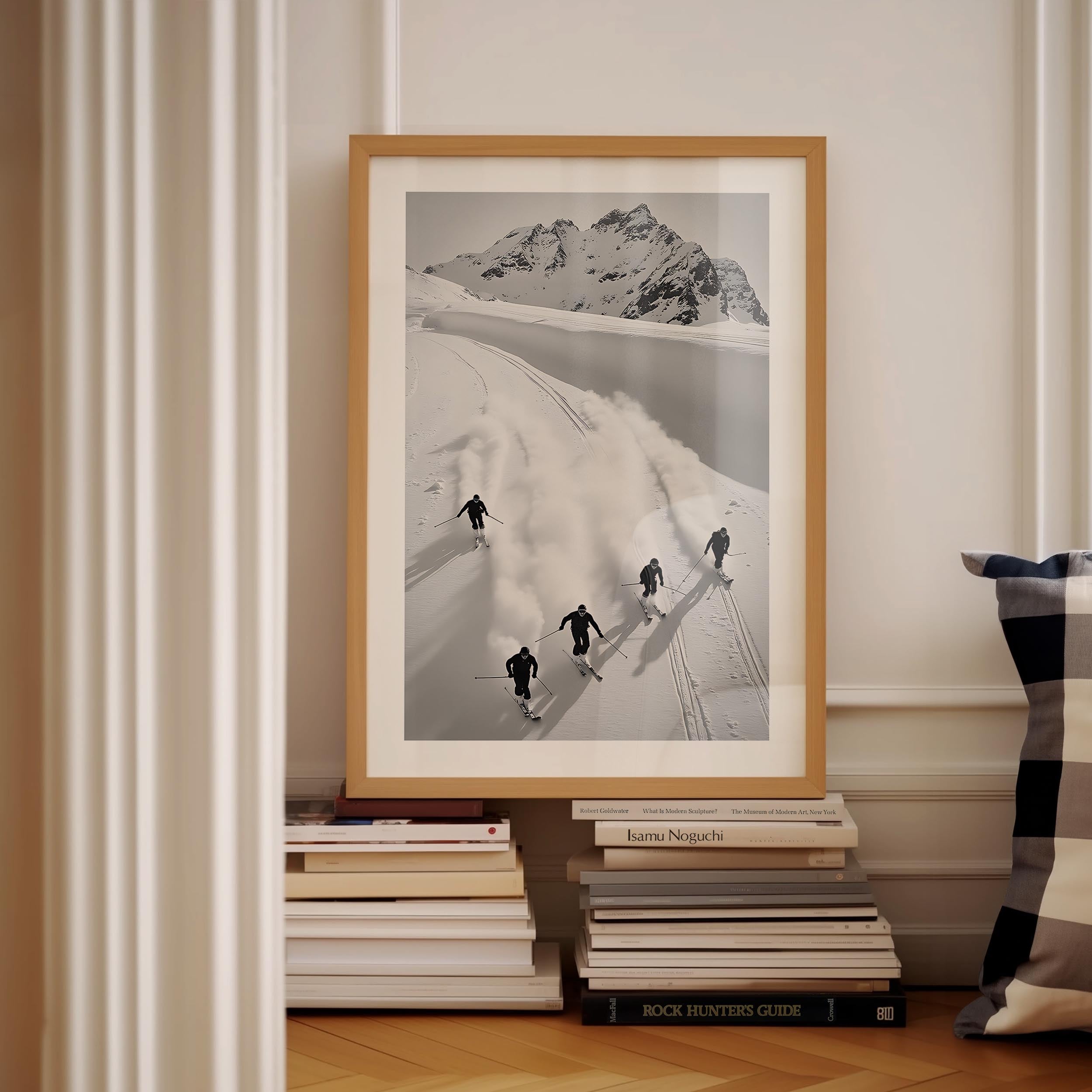 Black and white fine art print of five skiers carving through snow with mountains in the background, framed in black.