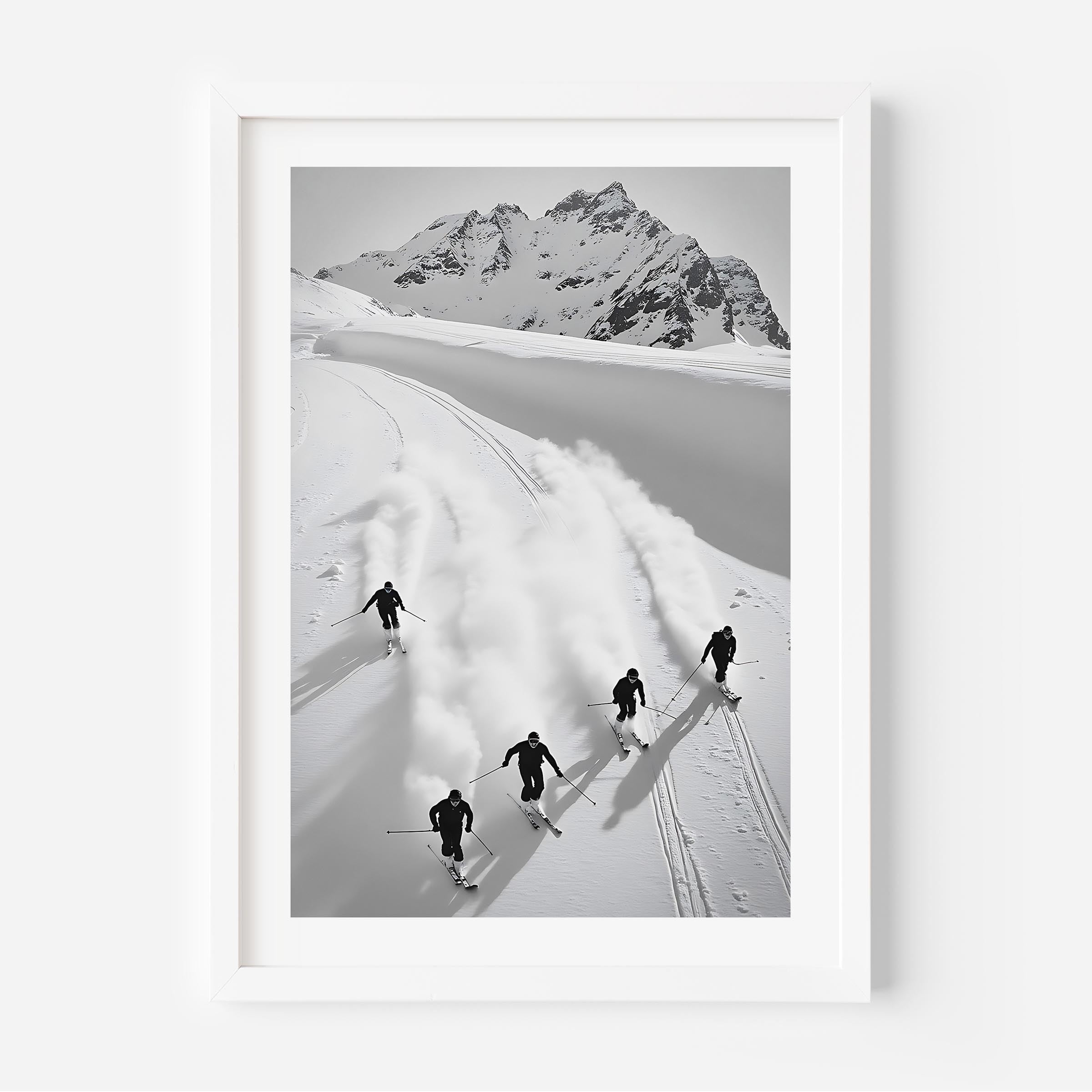 Black and white fine art print of five skiers carving through snow with mountains in the background, framed in black.