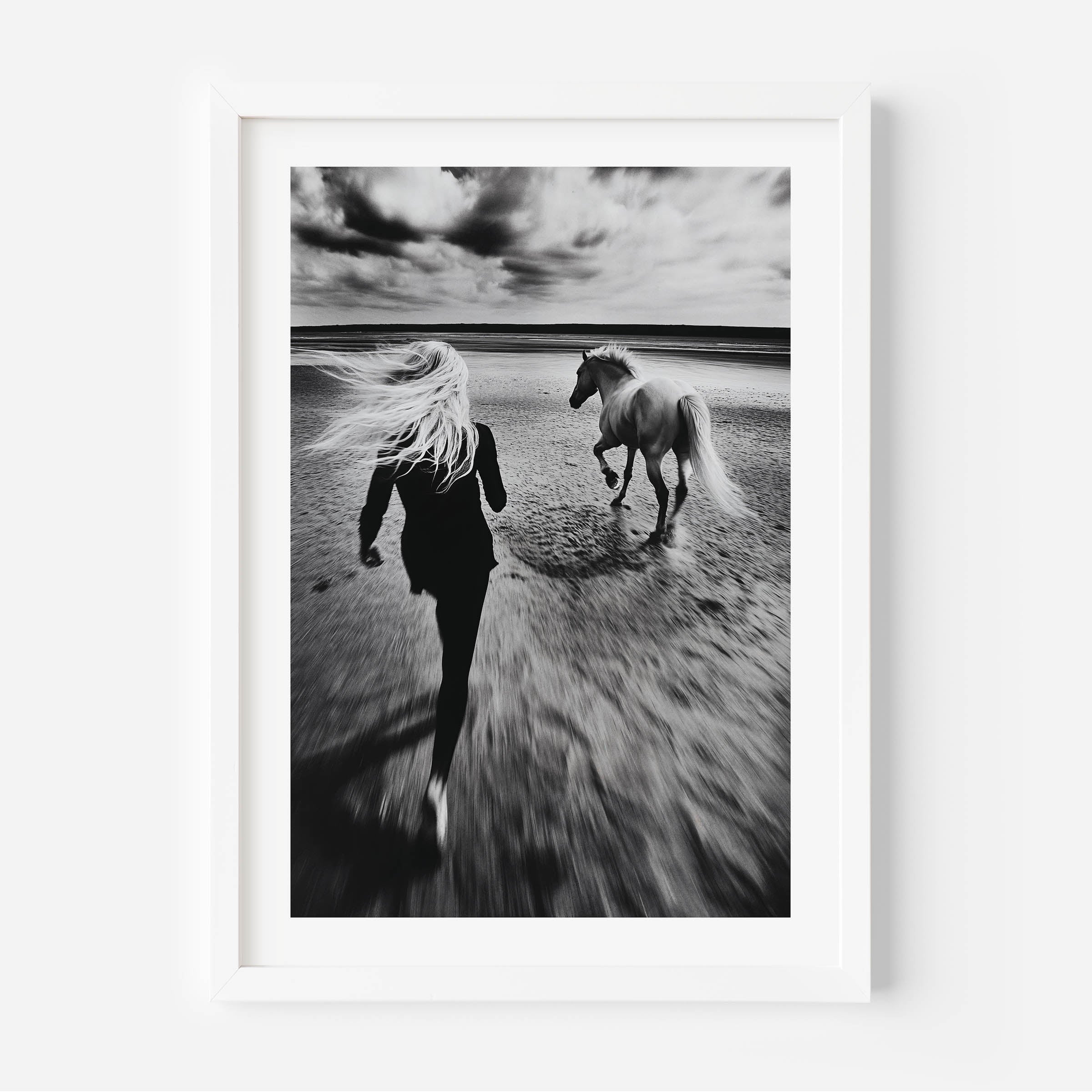 Black and white fine art print of a woman running freely alongside her horse on a vast, empty beach. The image exudes a sense of freedom, movement, and serenity, making it a perfect statement piece for modern, minimalist, or bohemian home decor. With its timeless monochrome tones and elegant composition, this artwork adds depth, sophistication, and a touch of nature’s beauty to any interior space.