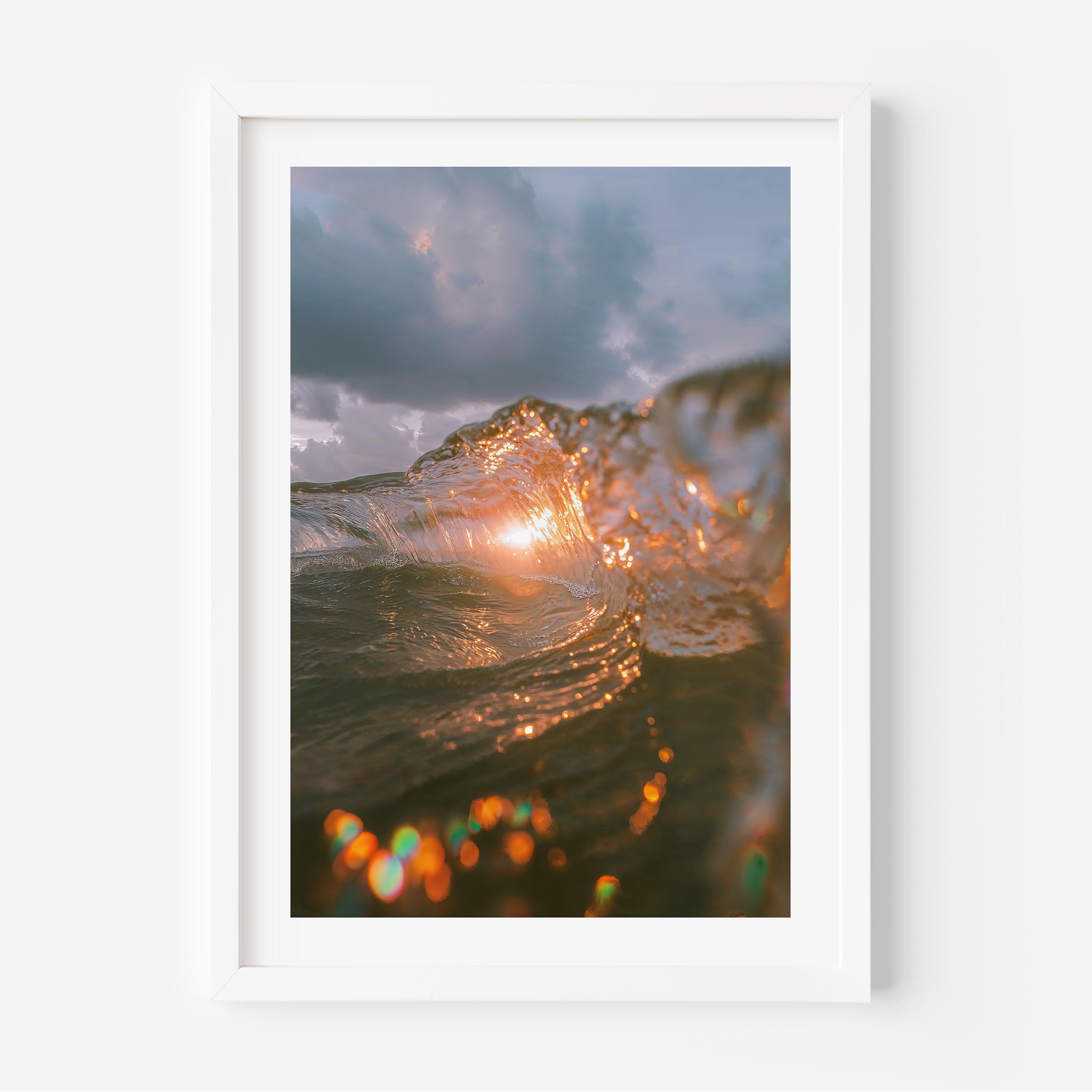 A fine art print of a wave crashing with the sun setting behind it, casting a golden glow on the water. The dynamic motion of the wave is beautifully captured, evoking a sense of energy and tranquility. Ideal for ocean and nature lovers.