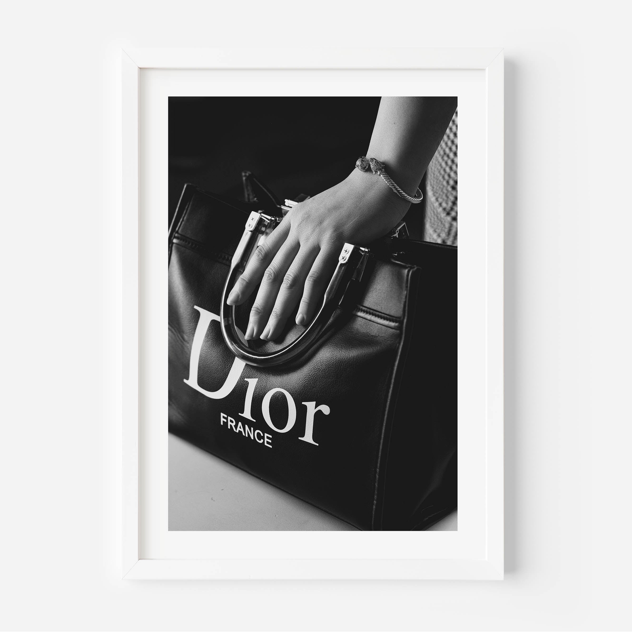 black and white poster of a woman holding a christian dior bag