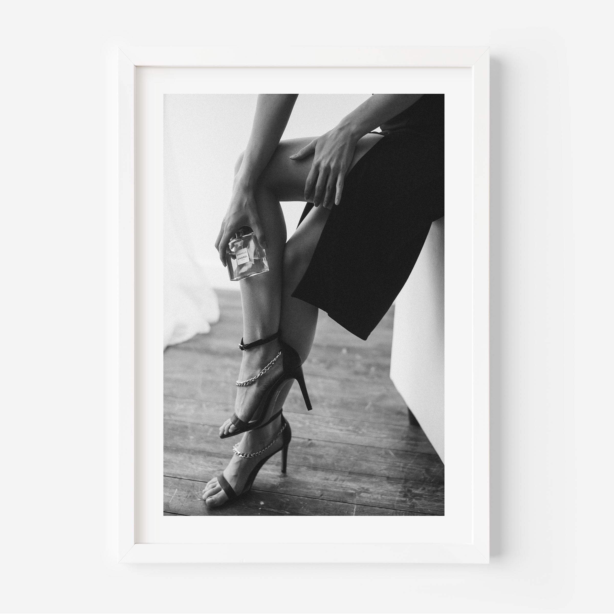 black and white poster of a woman holding a perfume bottle