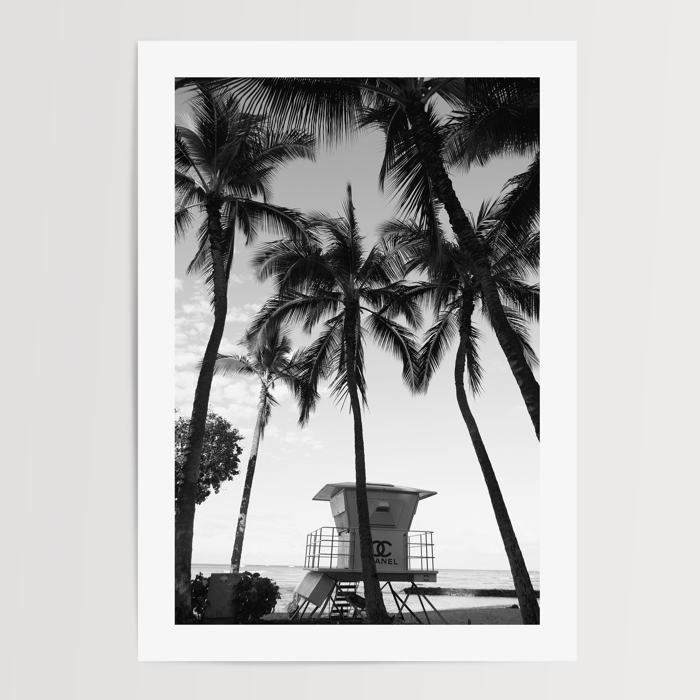black and white poster of a chanel lifeguard tower on a beach surrounded by plamtrees