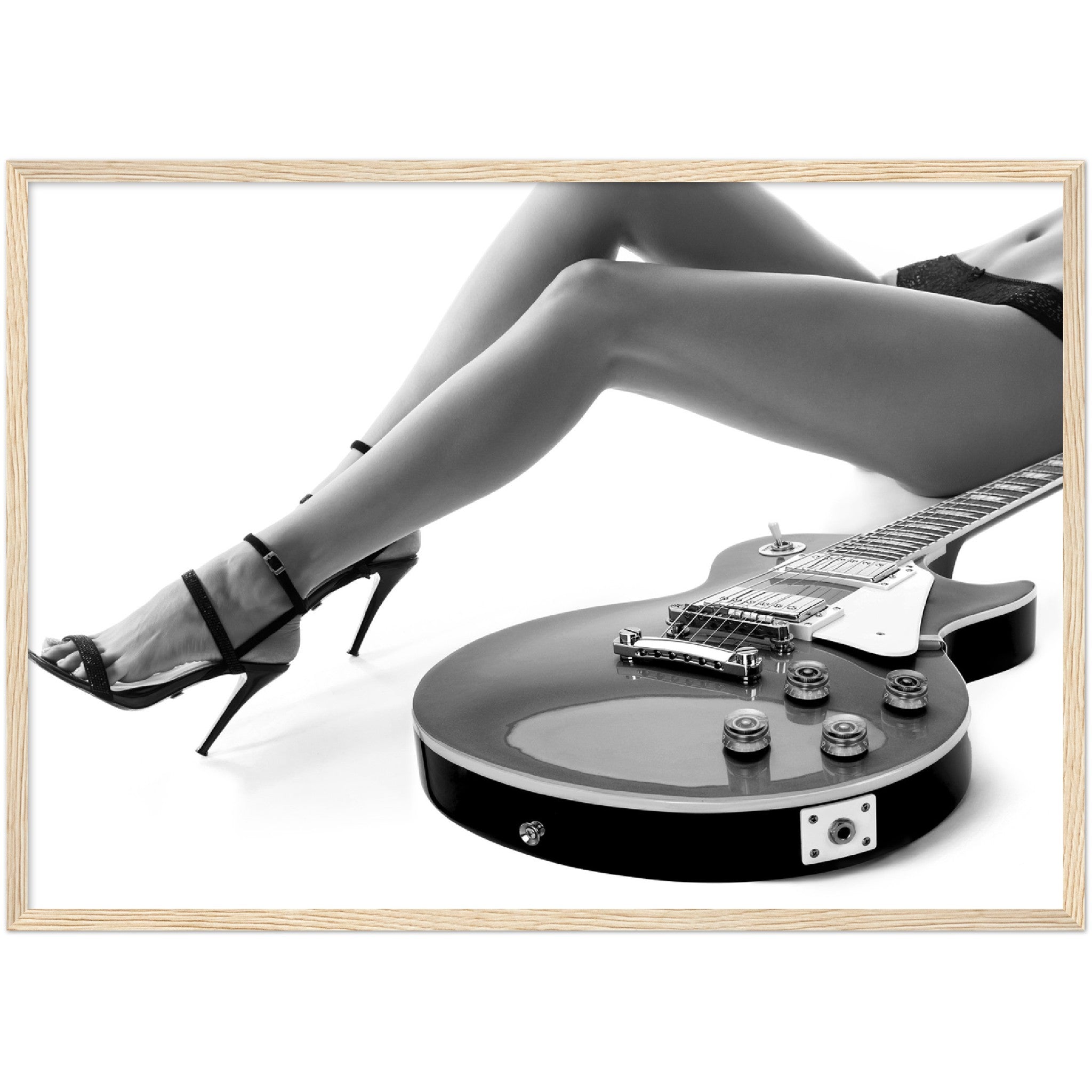 black and white framed poster of a sexy woman lying next to an electric guitar