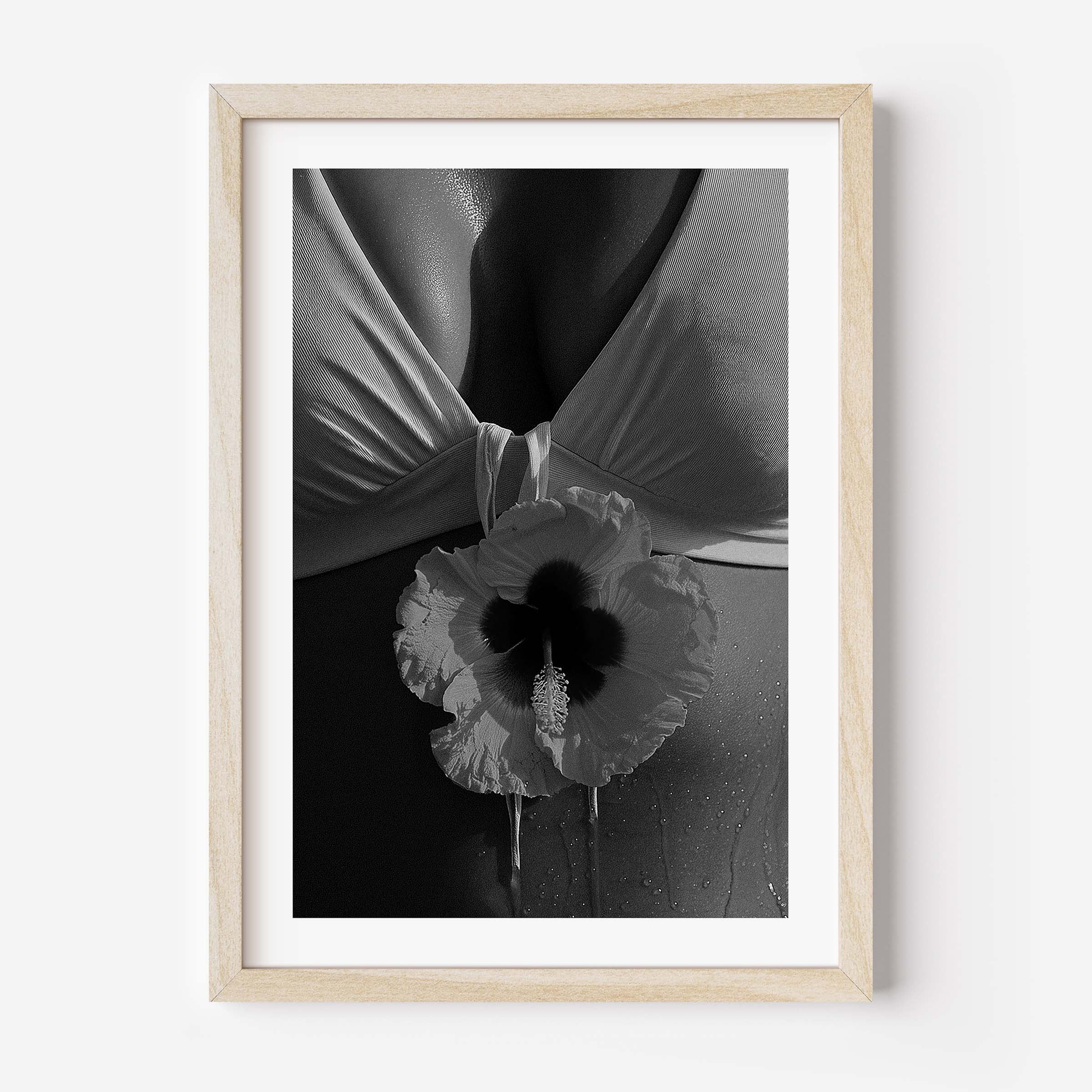 Black-and-white close-up photo print featuring a hibiscus flower against draped fabric and sunlit skin with water droplets.