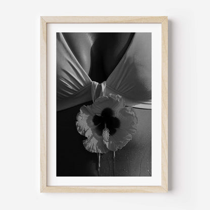 Black-and-white close-up photo print featuring a hibiscus flower against draped fabric and sunlit skin with water droplets.