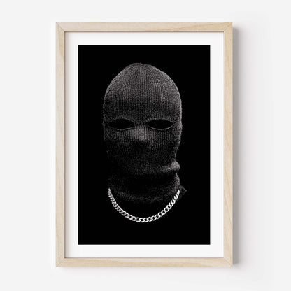 Black-and-white portrait of a person in a knit balaclava with eye cutouts and a silver chain on a solid black background, minimalist fine art print.