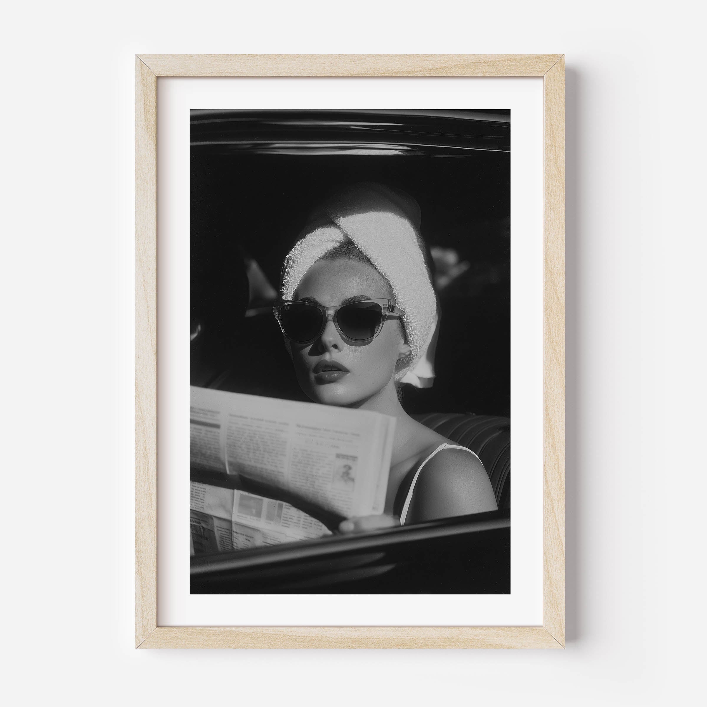 Channel vintage glamour with this black-and-white fine art print of a chic woman in sunglasses reading the paper. Perfect for stylish, fashion-inspired interiors.