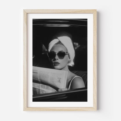 Channel vintage glamour with this black-and-white fine art print of a chic woman in sunglasses reading the paper. Perfect for stylish, fashion-inspired interiors.