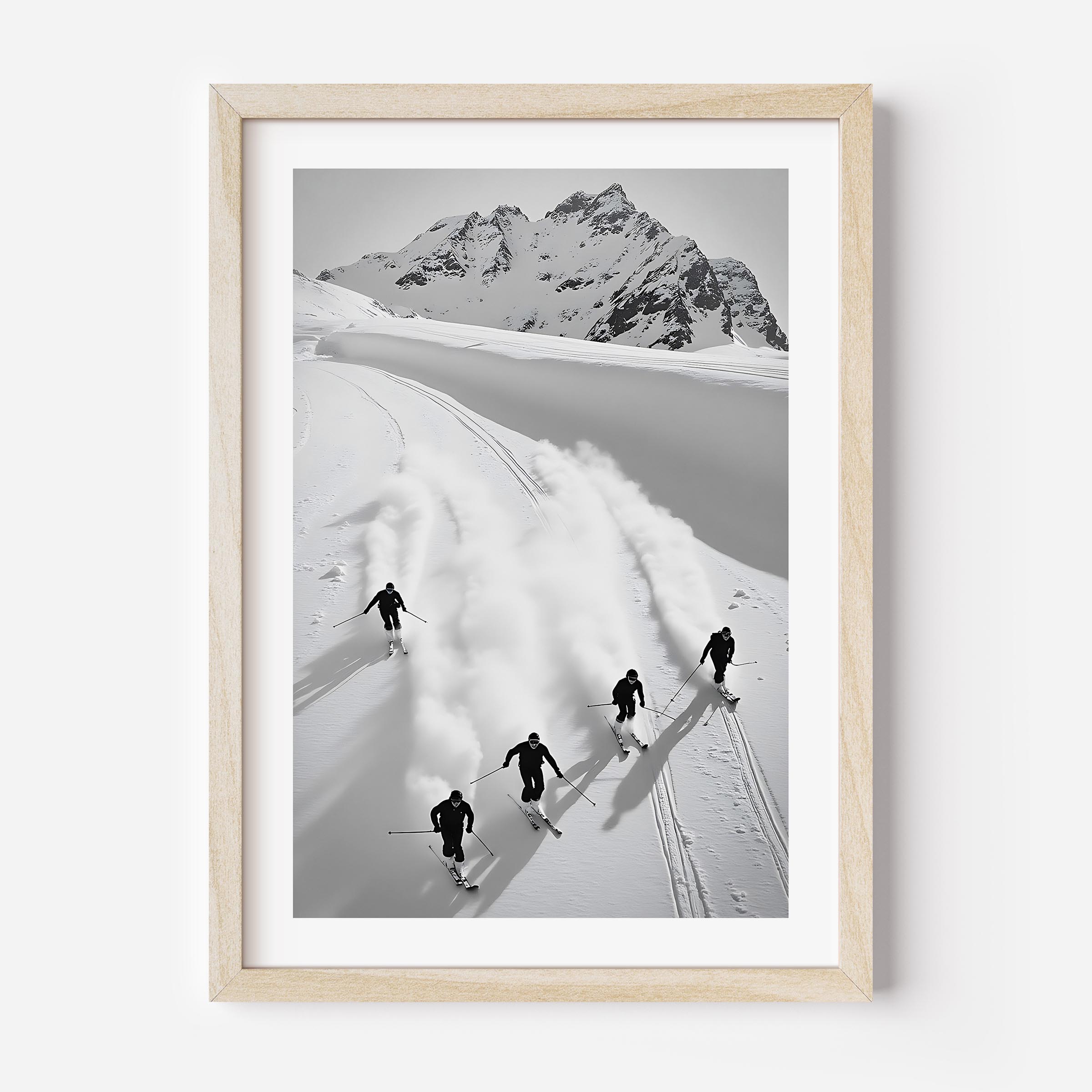Black and white fine art print of five skiers carving through snow with mountains in the background, framed in black.