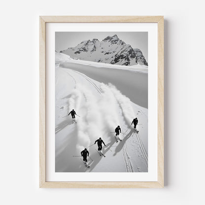 Black and white fine art print of five skiers carving through snow with mountains in the background, framed in black.