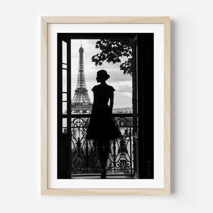 Black-and-white fine art photograph of a woman’s silhouette standing on a Parisian balcony with the Eiffel Tower in the background.