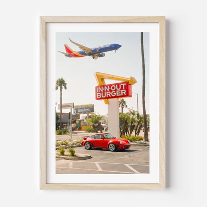 Red Porsche parked at In-N-Out Burger with airplane flying overhead – fine art wall print by Deston Isas