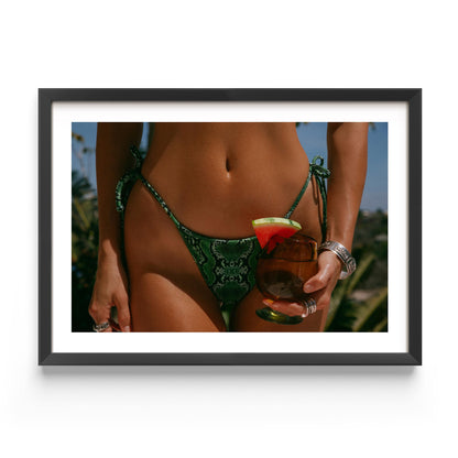 Framed fine-art photograph of a woman in an emerald snakeskin bikini holding a cocktail with a watermelon garnish; summer fashion editorial by Britt Van der Meyden.