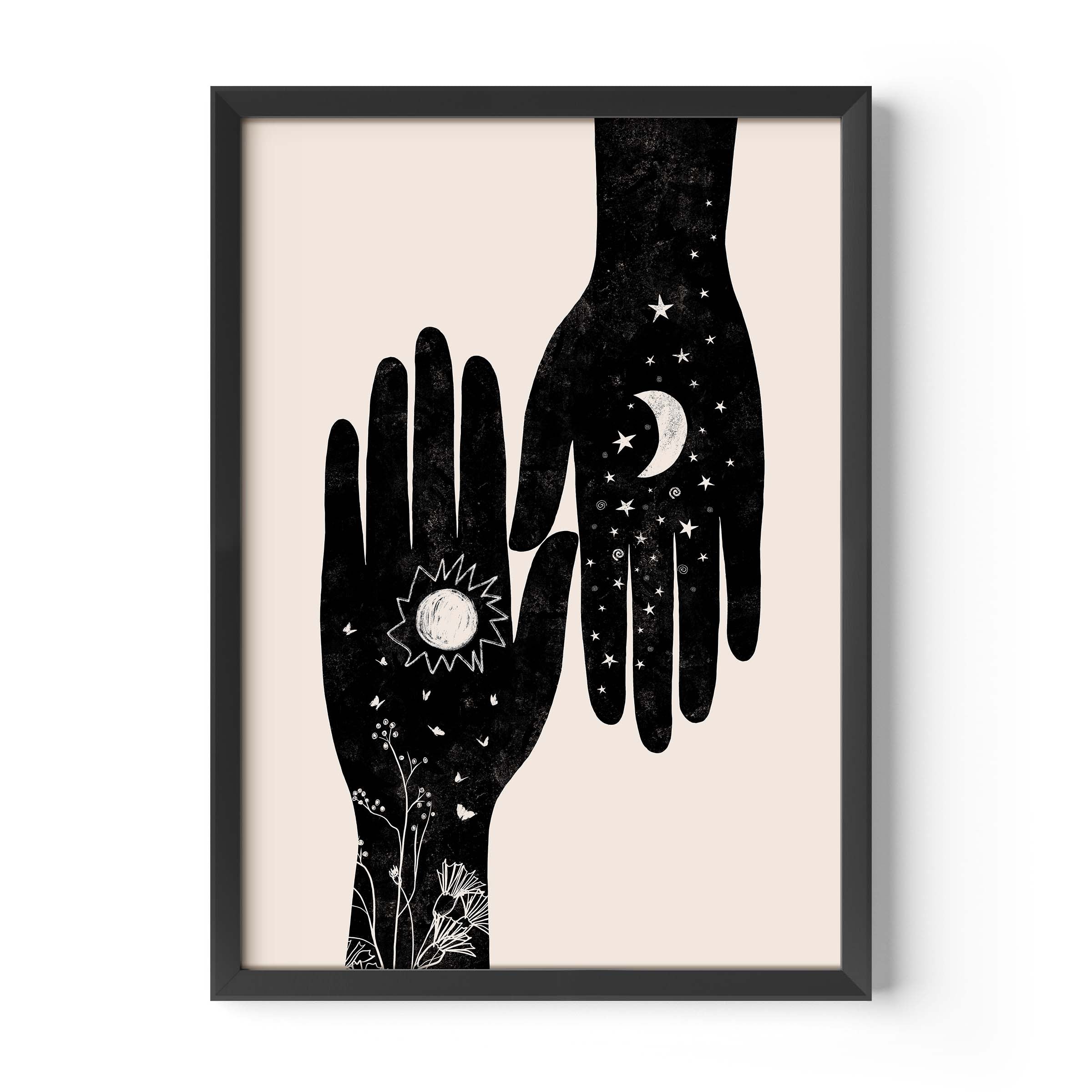 Framed wall art featuring a minimalist black illustration of two hands, one with a sun and floral details and the other with a crescent moon and stars, on a light beige background.