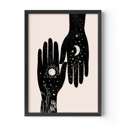 Framed wall art featuring a minimalist black illustration of two hands, one with a sun and floral details and the other with a crescent moon and stars, on a light beige background.