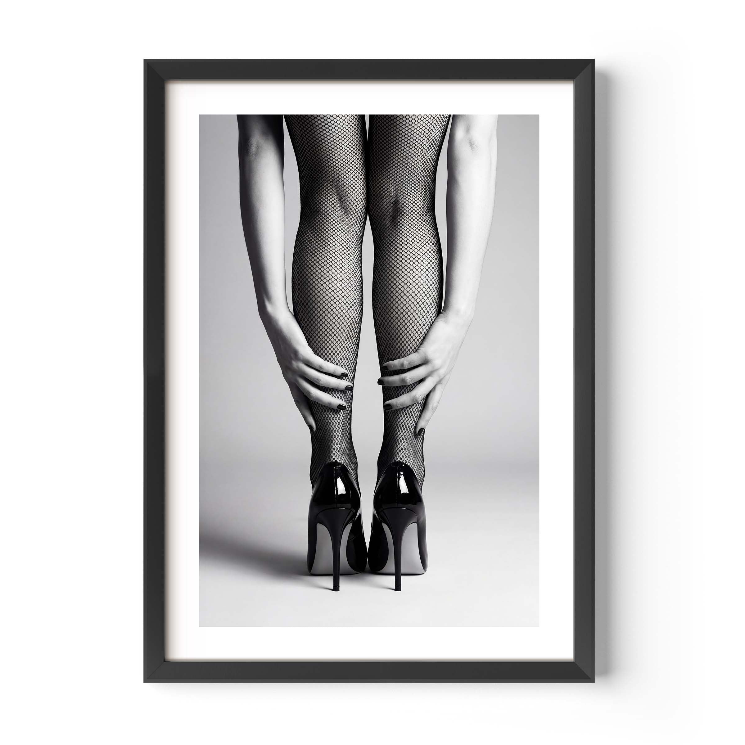 Framed black and white art print of legs wearing fishnet stockings and high heels on a gray background.