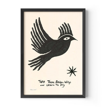 Framed art print by Eden Kalif featuring a bold black hand-drawn bird in flight on a cream background, with the handwritten text "Take These Broken Wings and Learn to Fly" and a small star motif. Printed on 230g matte paper in a black frame.