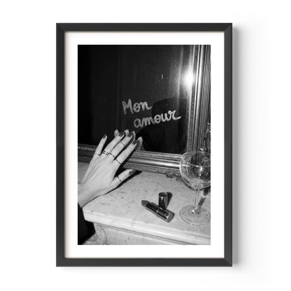 Framed black and white photo of a hand with rings near a mirror reflecting 'Mon amour'.
