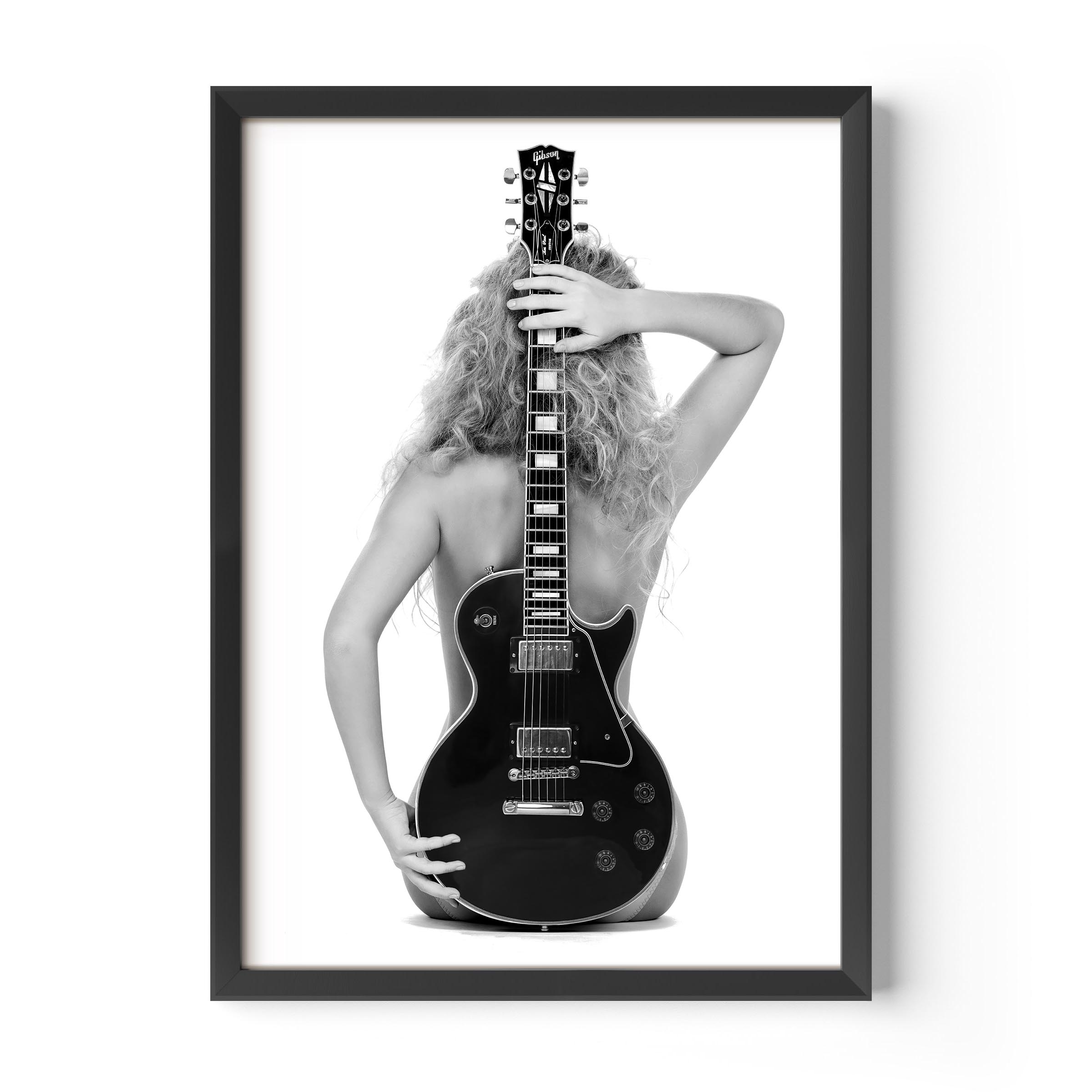 Black-and-white fine art print of a figure from behind holding an electric guitar on a white background.