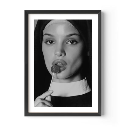 Black-and-white fine art photograph of a woman dressed as a nun, sensually holding a lollipop to her lips.