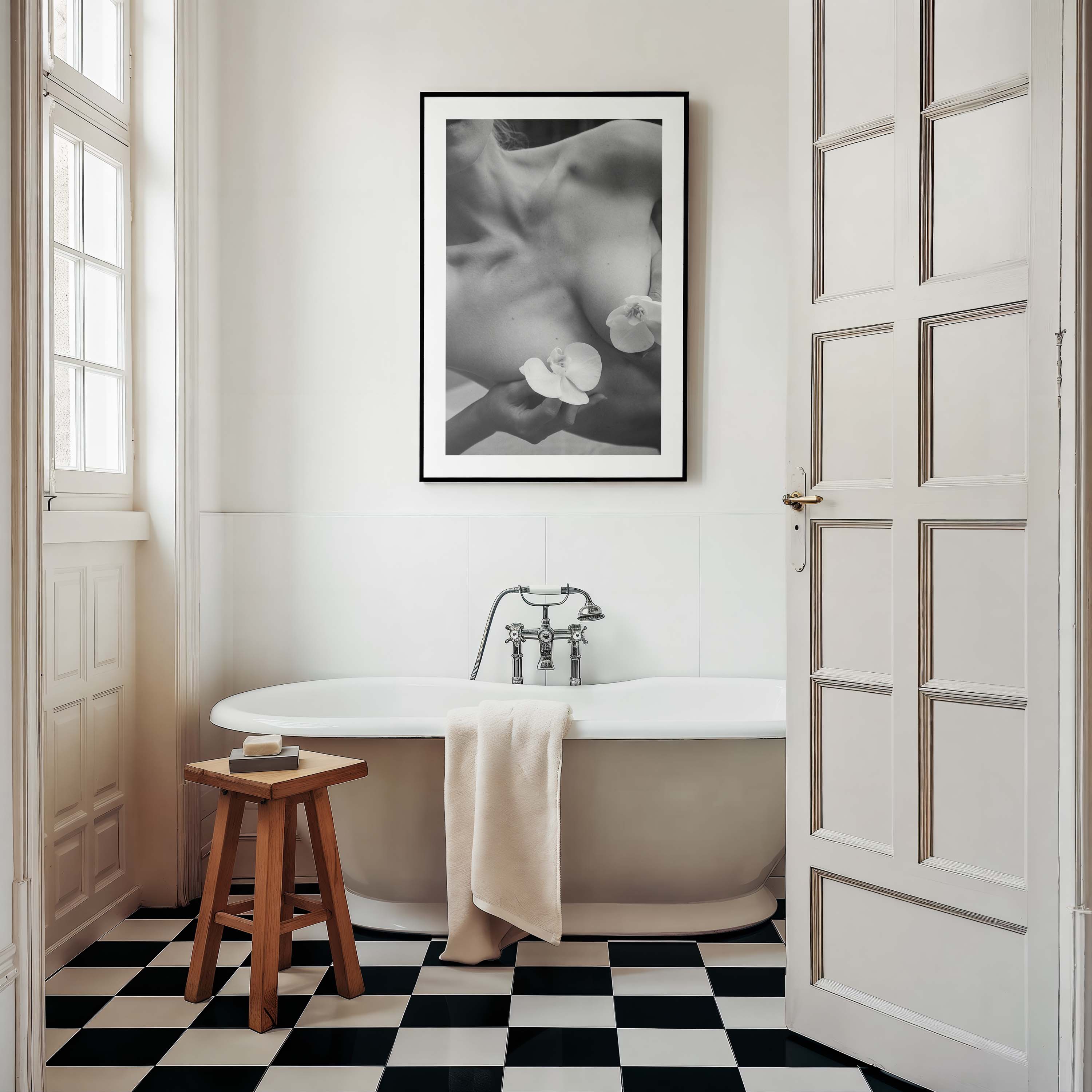 Framed black-and-white photograph of a woman’s collarbone with white orchid flowers, styled in a Parisian interior with molding, mirror, and chair — by Britt Van der Meijden.