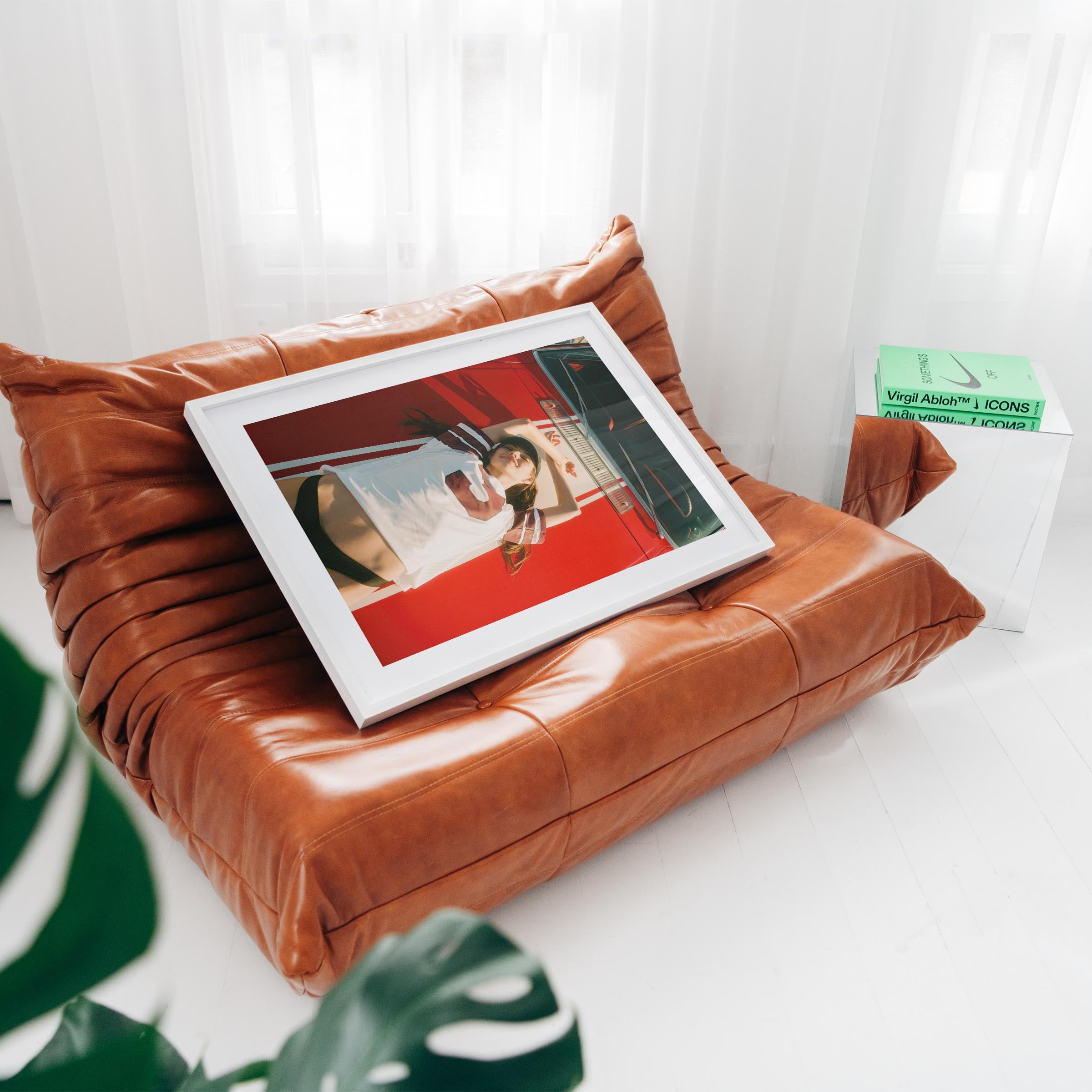 Fine art wall print of a young woman lying on a red car, evoking nostalgic teenage summer memories and carefree youth.