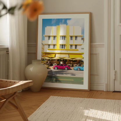 Fine art wall print of a colorful Miami street with Art Deco building and classic cars, evoking nostalgic summer road trip vibes.