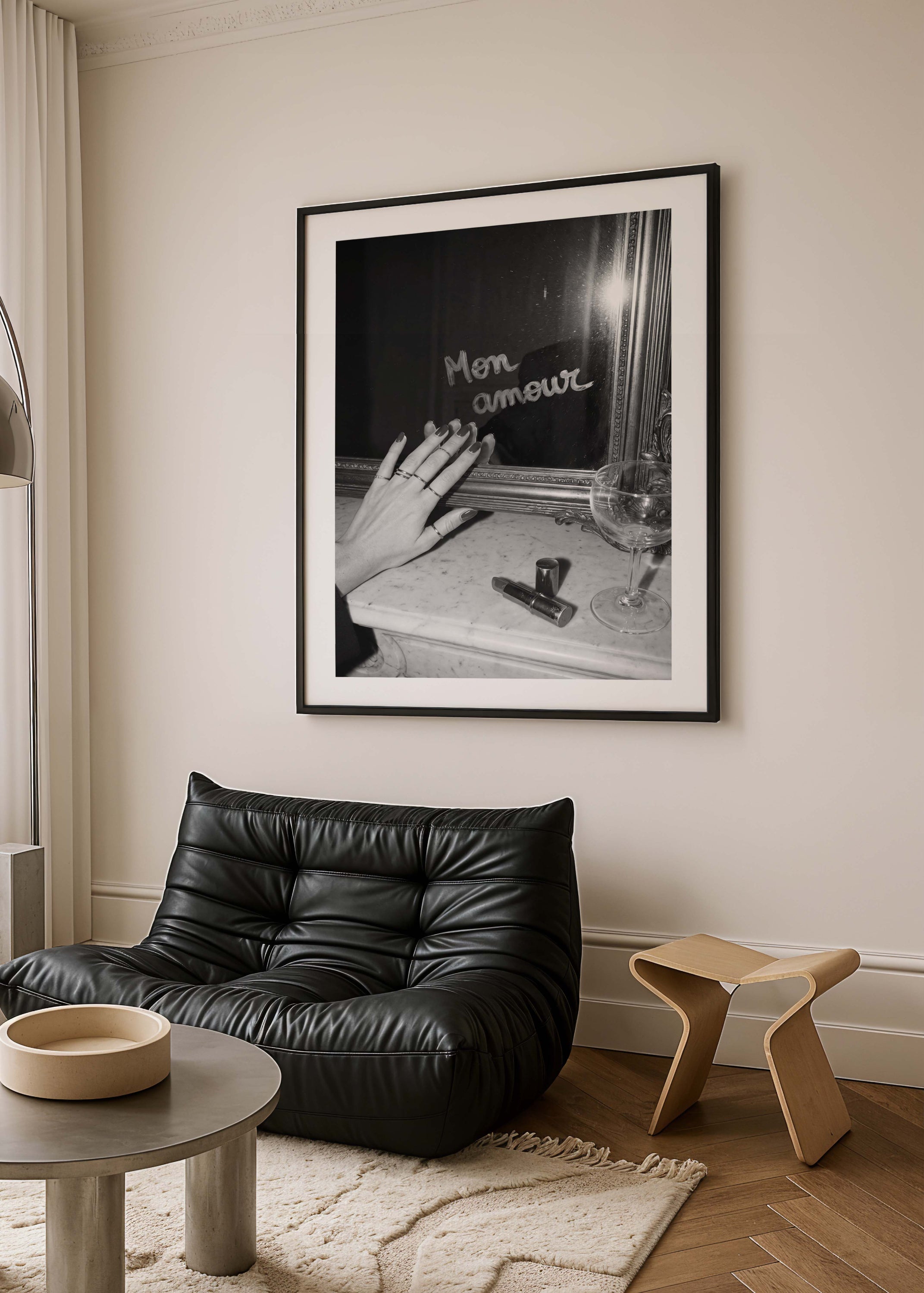 Black leather chair in a room with a framed black and white photograph on the wall.