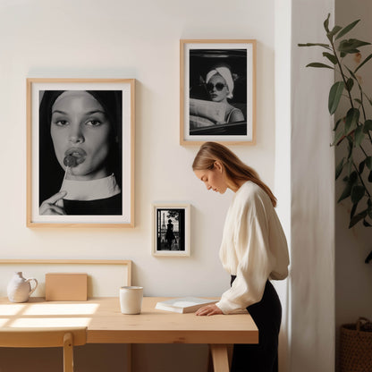 Black-and-white fine art photograph of a woman dressed as a nun, sensually holding a lollipop to her lips.