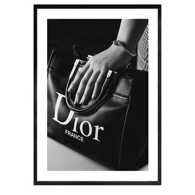 black and white poster of a woman holding a christian dior bag