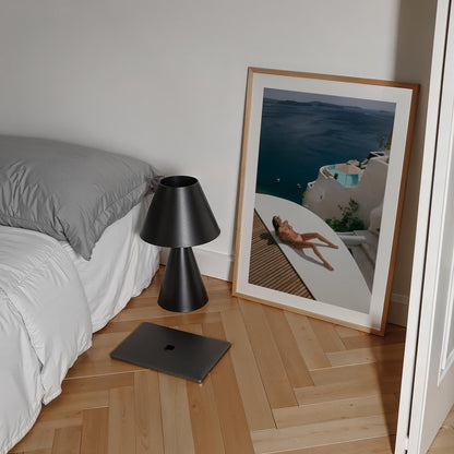 Woman sunbathing on a white terrace above a deep blue sea with whitewashed villas and a plunge pool, photographed by Britt van der Meijden