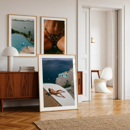 Woman sunbathing on a white terrace above a deep blue sea with whitewashed villas and a plunge pool, photographed by Britt van der Meijden