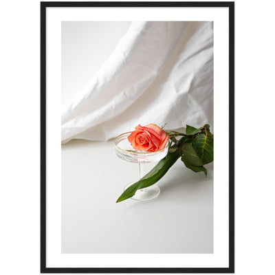 Lifestyle print of a rose in a champagne glass on a hotel bed